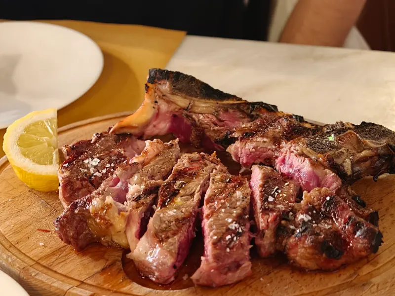 Costata alla fiorentina tagliata al sangue sul tagliere di legno
